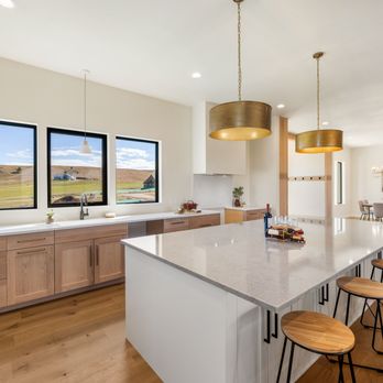 Custom light wood kitchen with quartz island and brass pendants