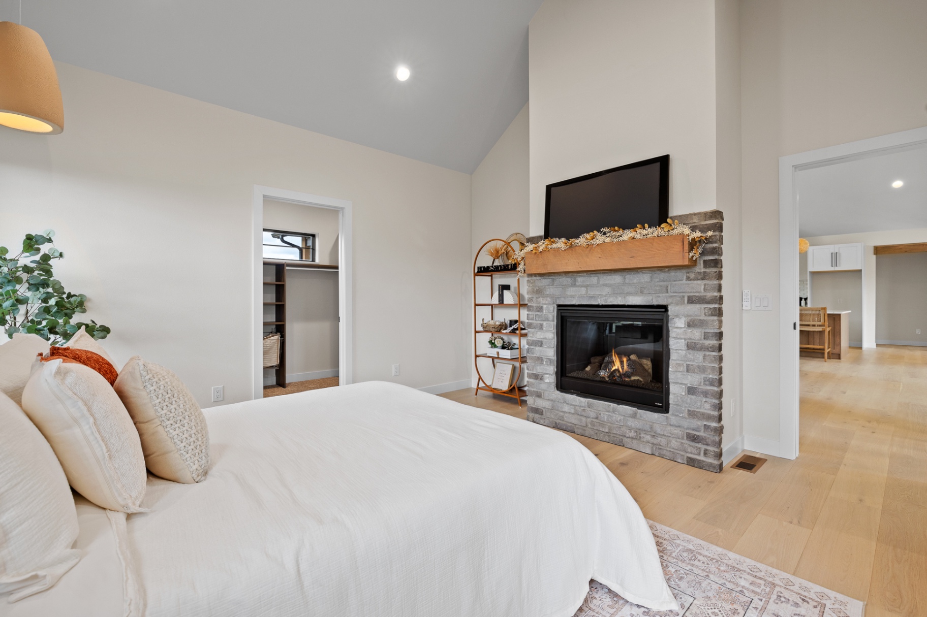 Primary suite with vaulted ceiling and brick fireplace