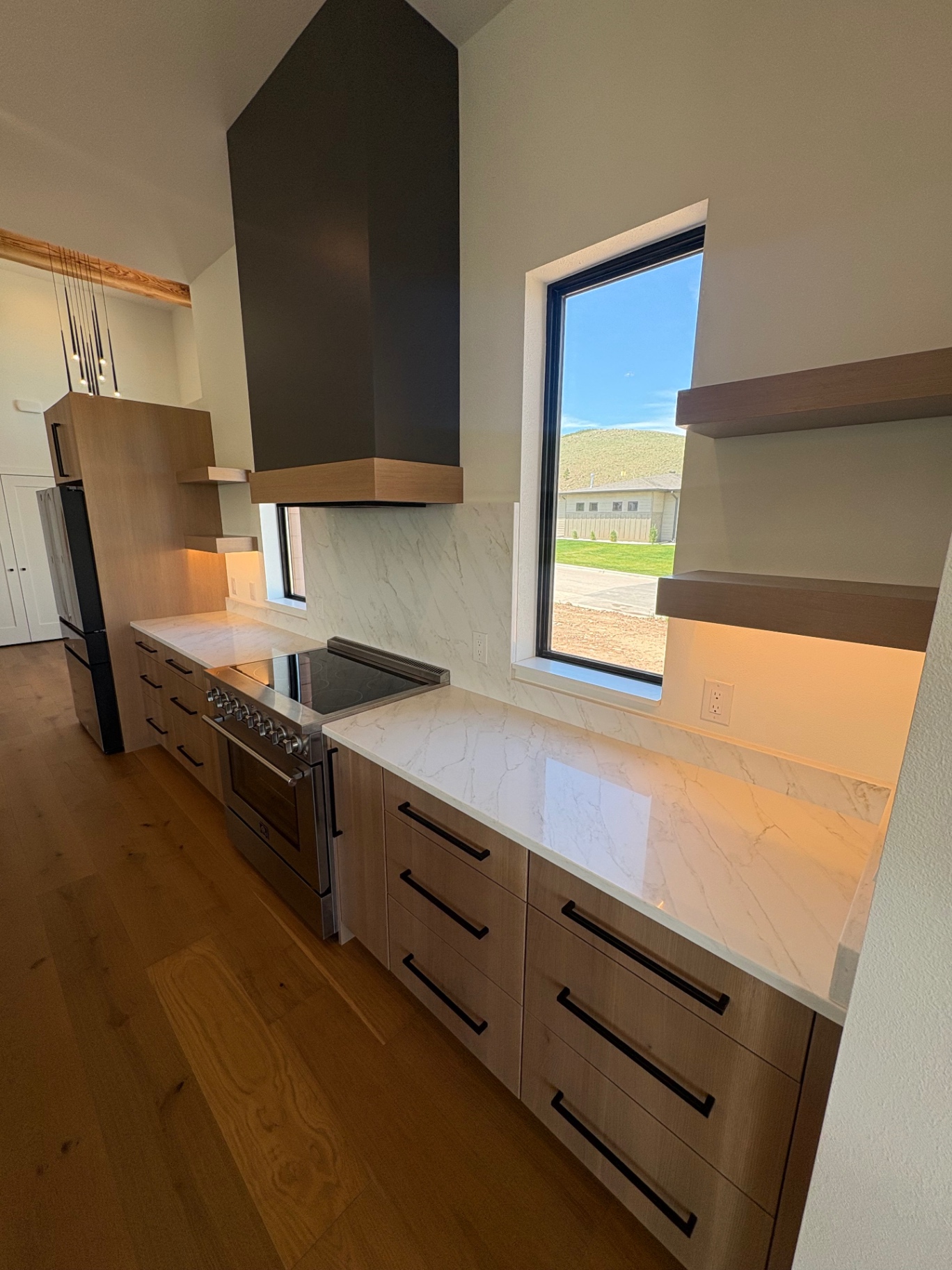 White oak kitchen run with quartz backsplash, custom timber hood shroud and floating shelves