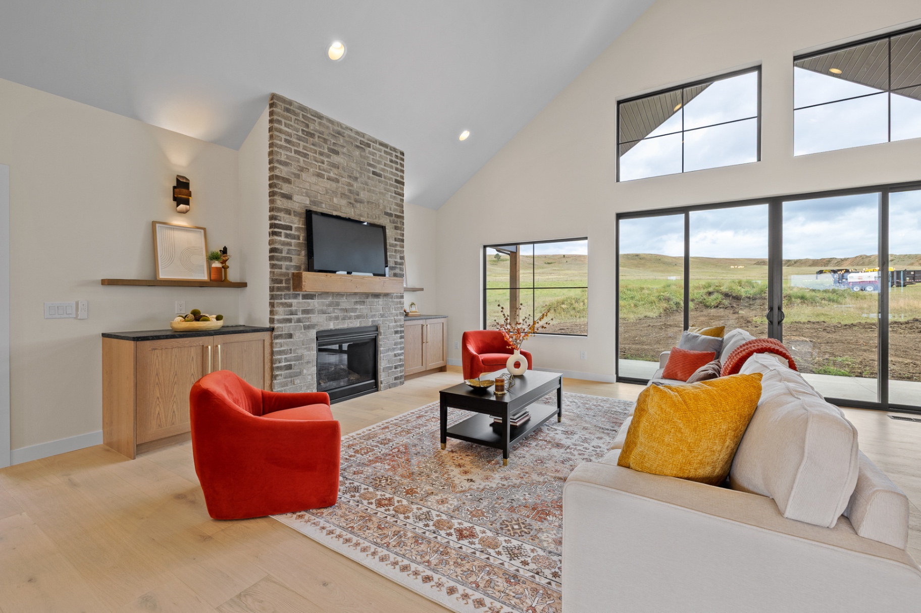 Great room with brick fireplace, timber mantel and custom white oak flanking cabinetry