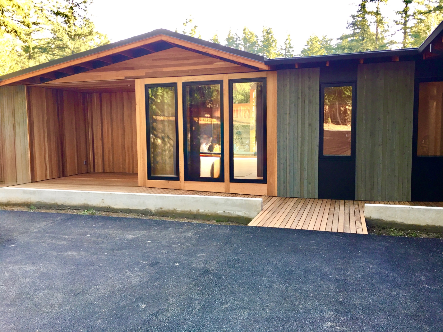 Cedar-clad covered entry with full-height glass doors