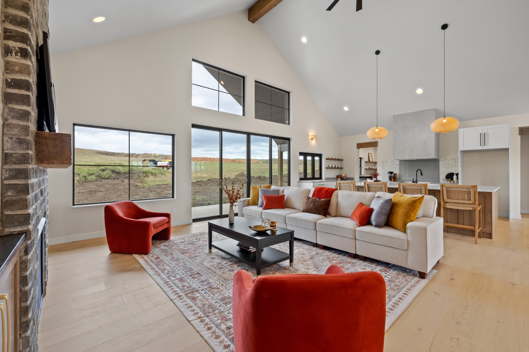 Vaulted great room with brick hearth, clerestory windows and open kitchen beyond