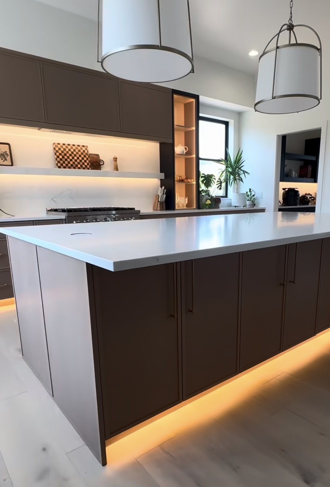 Custom dark cabinetry and island with integrated lighting in a Newhouse Builds kitchen