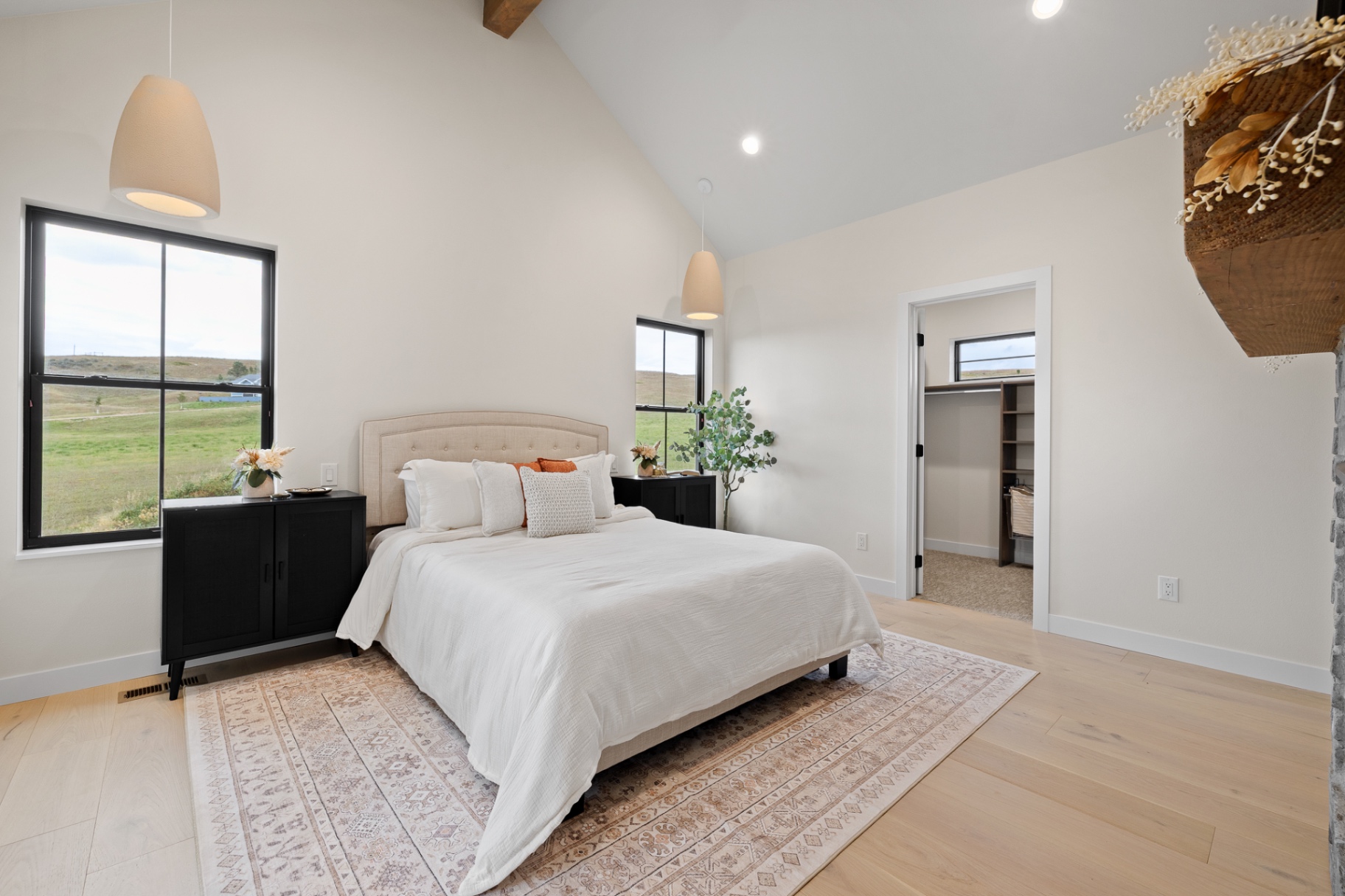 Guest suite with vaulted ceiling, black windows, custom closet and prairie views
