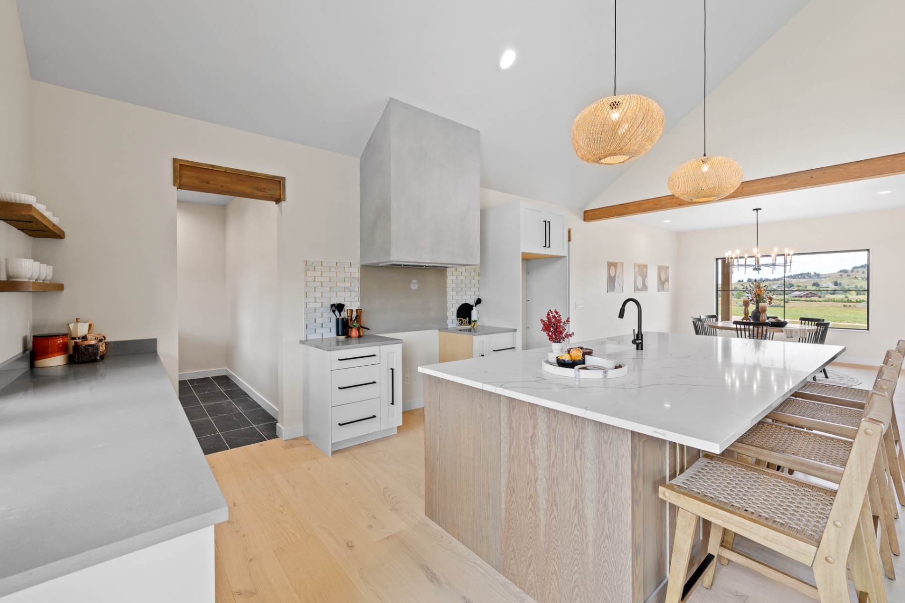 Vaulted custom kitchen with plaster hood, white oak island and woven pendants