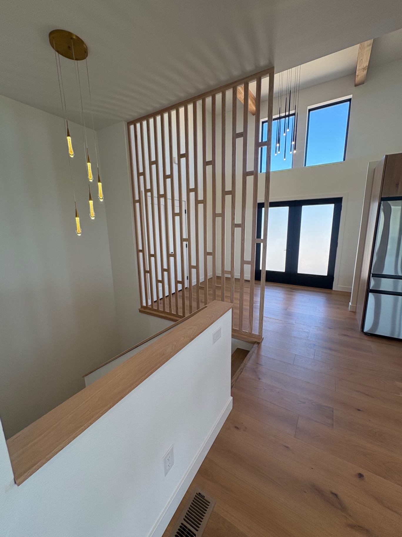 White oak slat partition dividing an entry from an open interior
