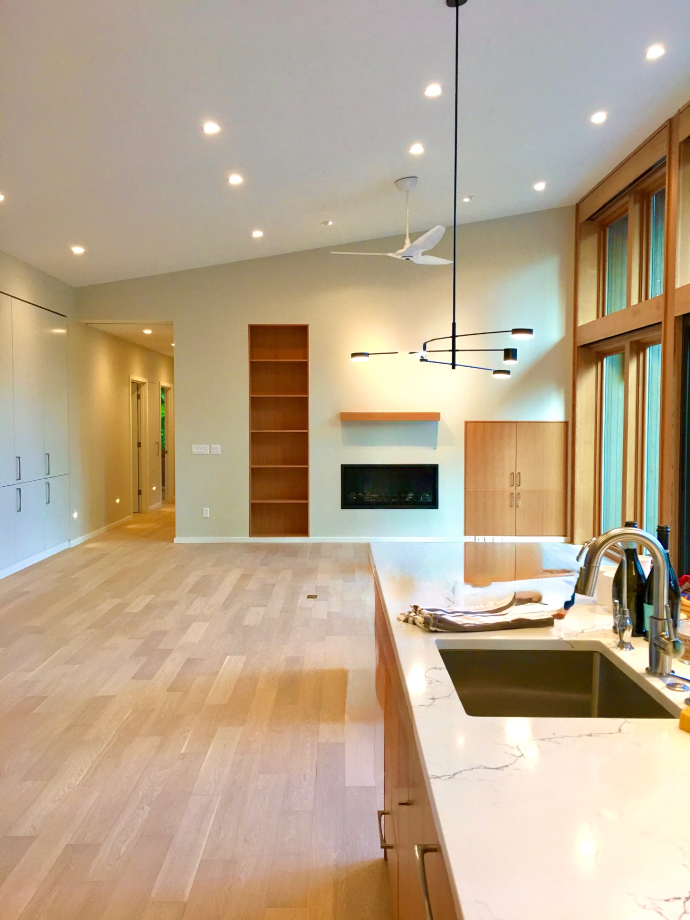 Great room with custom paneled fireplace wall and beamed ceiling