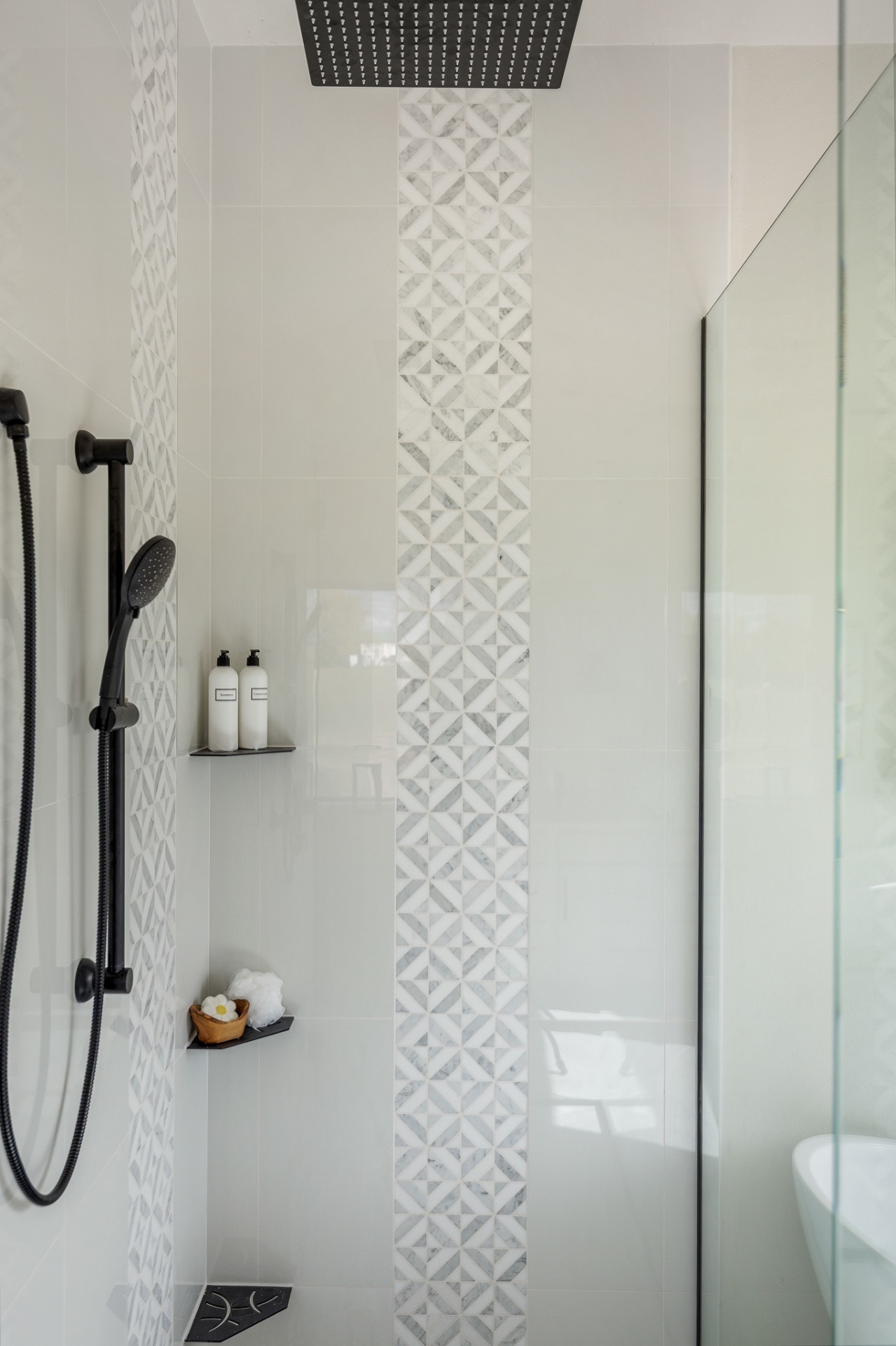 Tiled shower with marble mosaic inlay and matte black rain head