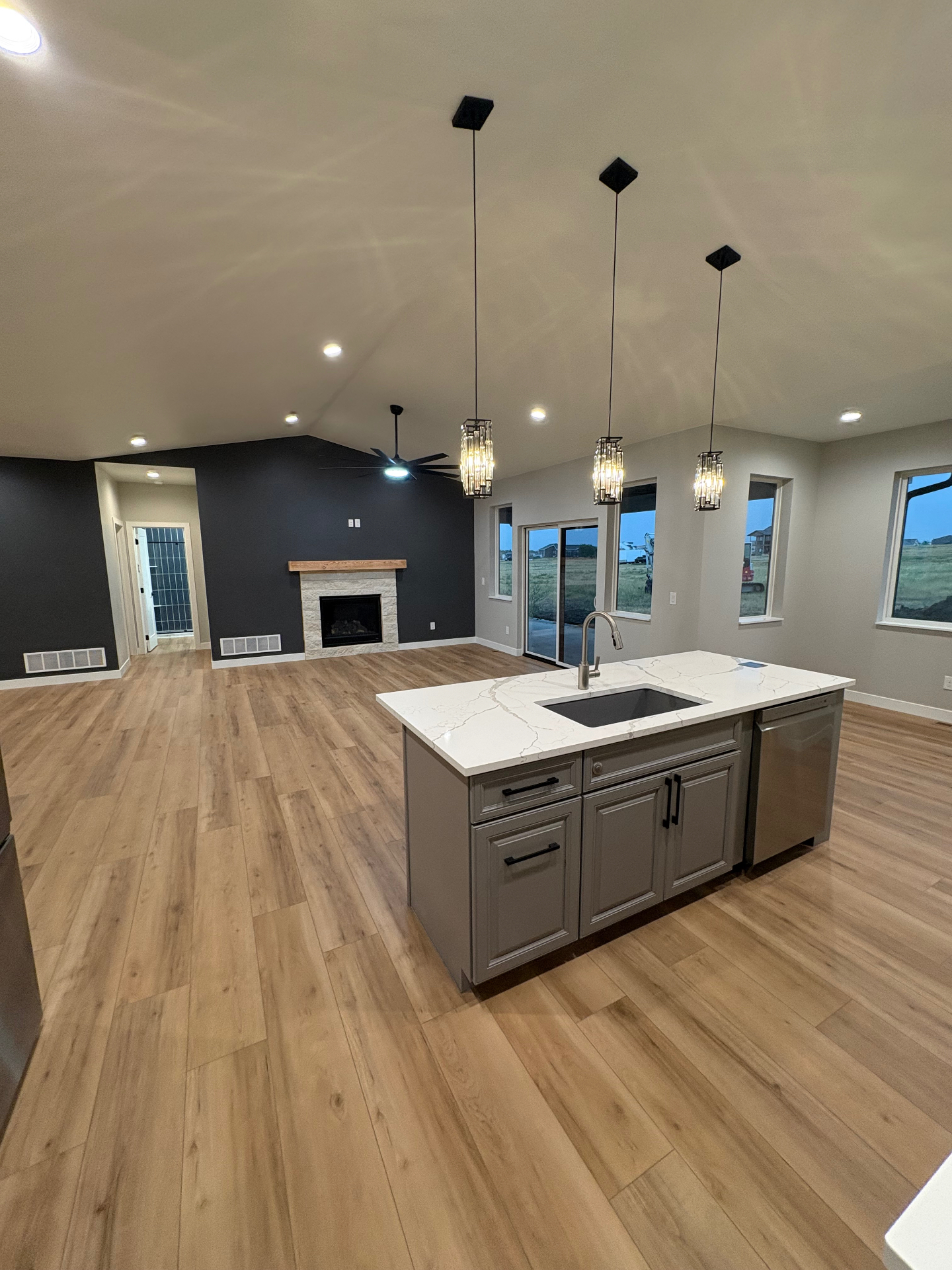 Open kitchen and living room with grey island, quartz top and vaulted ceiling