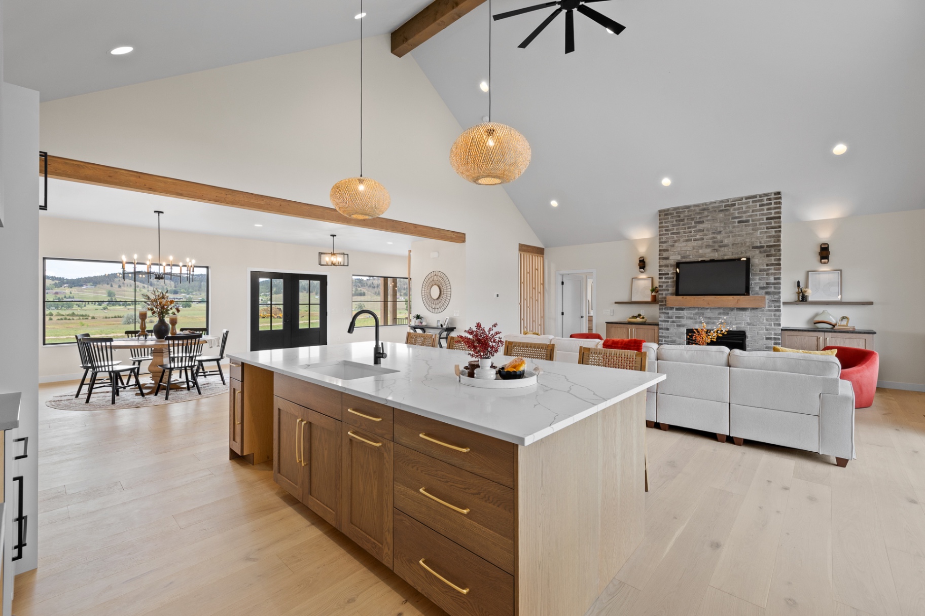 Open kitchen with stained oak island, brass pulls, exposed timber beams and dining beyond