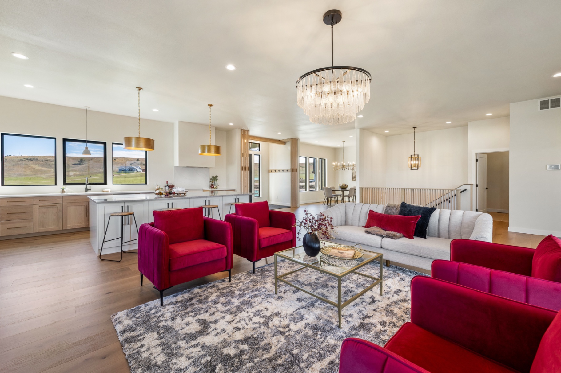 Open-concept great room, kitchen and dining with white oak floors and prairie views
