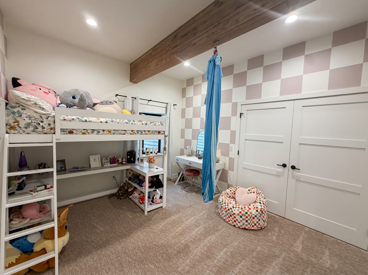 Bedroom with a loft bed, built in desk, checkerboard accent wall and indoor aerial hammock